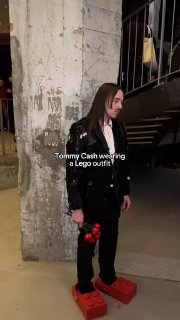 Выступление в Париже: Томми Кэш в черном костюме и массивной паре красной обуви-«кирпичей» в индустриальном интерьере на презентации коллаборации.