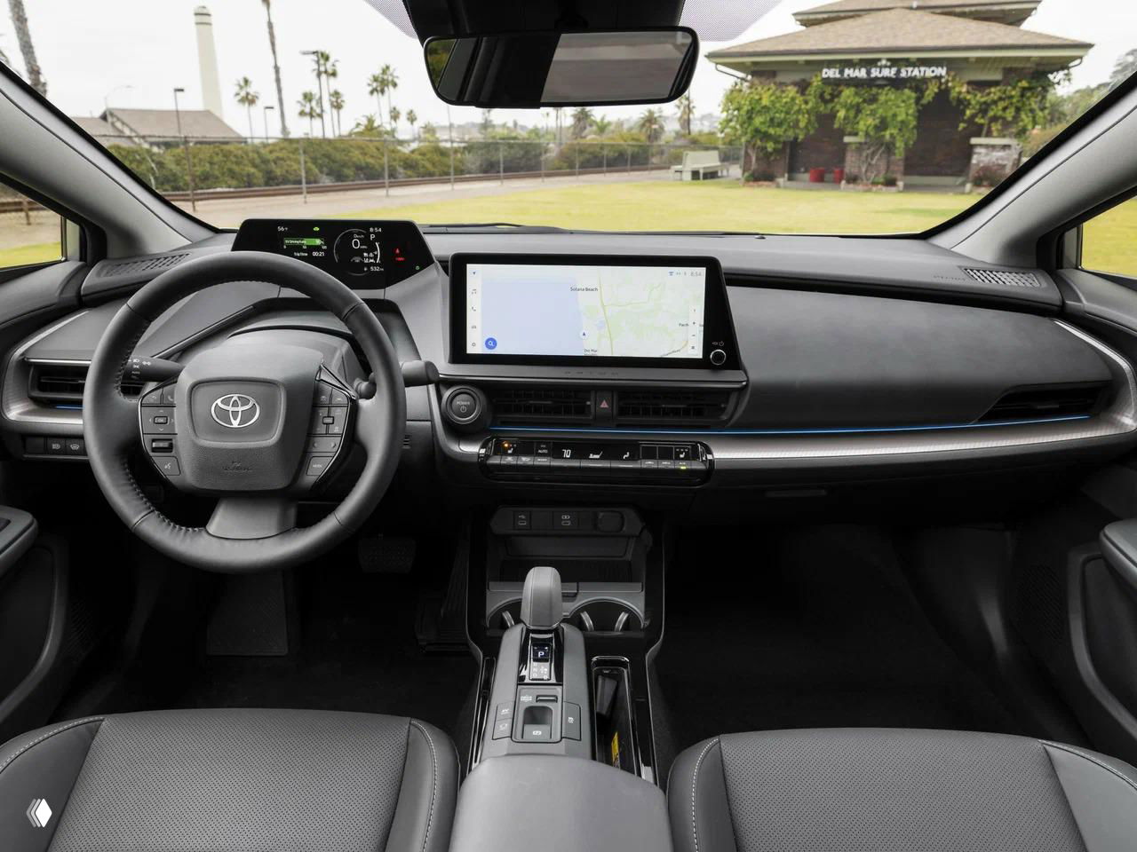 Салон Toyota Prius с крупным центральным и панелью приборов, вид на руль и большой планшет мультимедиа в стиле современного гибрида