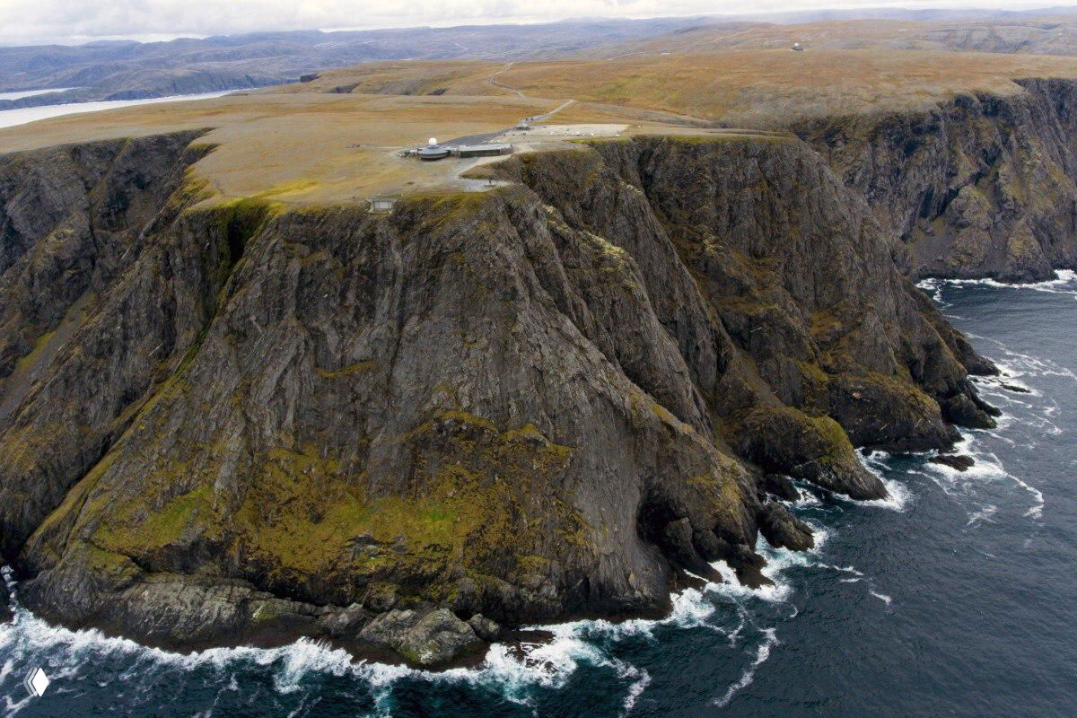 Обрывистый прибрежный мыс с крутыми скалами и бушующим морем — вид сверху на скалистый берег северного побережья.