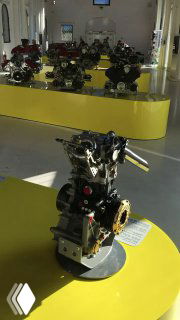 Ряд двигателей и технических узлов на желтых постаментах в отдельном зале музея, демонстрация механики и инженерной части Ferrari.