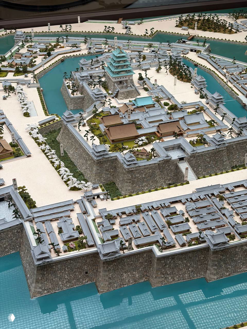 Детализированная макетная модель замка Осаки и окружающей крепостной системы с рвами, стенами и кварталами, вид сверху в экспозиции музея.